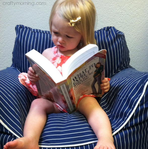 little-girl-reading-what-to-expect-pregnancy-announcement